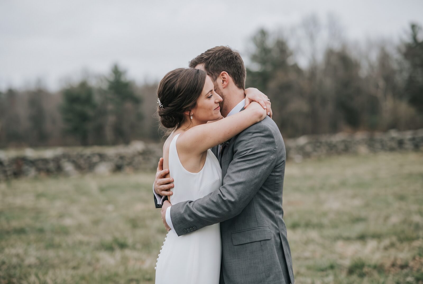 A bride and groom embracing outdoors before a colour grade is applied